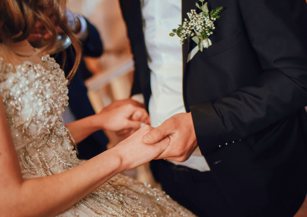 gros plan intime sur les mains de mariés se tenant, illustrant l'organisation d'un mariage serein en semaine par une wedding planner expérimentée du 77.